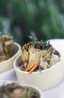 Artichokes in barigoule sauce in white pot — Stock Photo