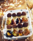 Closeup view of different candies with nuts and dried fruit on platter — Stock Photo
