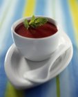 Closeup view of strawberry soup with mint in white bowl — Stock Photo