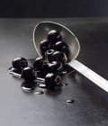 Черные оливки на ложке — стоковое фото