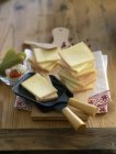 Sliced cheese on wooden plate — Stock Photo