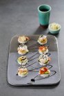 Huit mini hamburgers de sushi sur plaque de céramique — Photo de stock