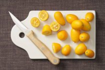 Kumquats frais sur planche à découper — Photo de stock