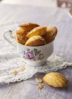 Vintage tea cup full of madeleines — Stock Photo