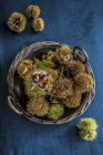 Top view of thorny chestnuts in a basket — Stock Photo