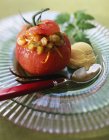 Tomato on plate with spoon — Stock Photo