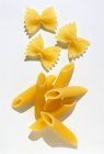 Uncooked penne and farfalle pasta pieces — Stock Photo