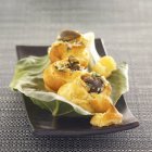 Blätterteig gefüllt mit Schnecken aus Bourgogne auf schwarzem Teller über textiler Oberfläche — Stockfoto