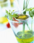 Vaso de aceite de oliva con hierbas frescas y cuchara - foto de stock