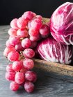Closeup view of purple grapes bunch with radicchio — Stock Photo