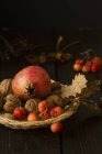 Closeup view of still life with pomegranate, walnuts and cherries — Stock Photo