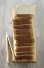 Vista close-up de fatias empilhadas de pão com pinças — Fotografia de Stock