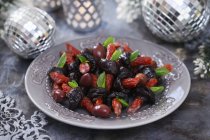 Kabanos with prunes on grey plate over table — Stock Photo