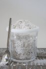 Nahaufnahme von frischen Kokosraspeln in Plastikschale mit Löffel — Stockfoto