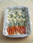 Baby vegetables covered in cling film — Stock Photo