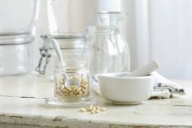 Соснові горіхи в склянці і розчин на сільському кухонному столі — стокове фото