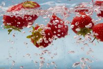 Morangos em água com bolhas — Fotografia de Stock