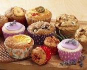 Muffins e cupcakes em tábua de madeira — Fotografia de Stock