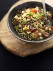 Салат из чечевицы в черной миске — стоковое фото