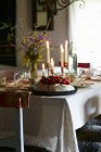 Naturaleza muerta con Pavlova y velas en una mesa puesta - foto de stock