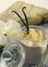 Azúcar de caña con cáscaras de vainilla y limón en frasco de vidrio - foto de stock