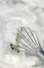 Nahaufnahme von geschlagenem Eiweiß und einem Schneebesen — Stockfoto