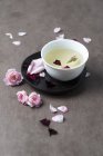 Vista de perto de chá e pétalas de rosa — Fotografia de Stock