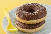 Donuts de chocolate en el plato - foto de stock