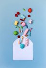 Draufsicht auf bunte Süßigkeiten und Umschlag auf hellblauer Oberfläche — Stockfoto