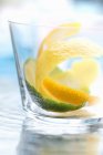 Крупним планом вид на лимонні і лаймові шкірки в склі — стокове фото