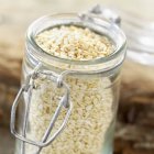 Small glass jar of sesame seeds — Stock Photo
