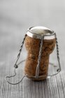 Closeup view of one bottle cork with wire on wooden surface — Stock Photo