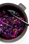 Red cabbage with orange peel  in bowl on white surface — Stock Photo