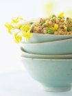 Cereales mezclados con guisantes en tazón verde sobre superficie blanca - foto de stock