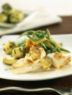 Carne alla griglia con patate ed erbe su piatto bianco — Foto stock