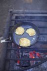 Pancakes in pan on fire grate — Stock Photo