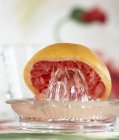 Hälfte Grapefruit und Saftpresse — Stockfoto