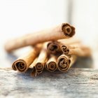 Closeup view of cinnamon sticks heap on wooden surface — Stock Photo