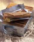 Closeup view of Gavottes crispy crepes on foil and in metal dish — Stock Photo