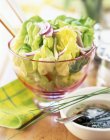 Листя салату в скляному горщику над столом — стокове фото