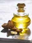 Closeup view of glass bottle with oil and Argan nuts — Stock Photo