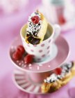 Chocolate mousse eclairs on decorated tea cups — Stock Photo