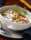 Closeup view of seafood and shellfish soup with herb in bowl — Stock Photo