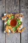 Vue du haut des cuisses de grenouille frites avec salade et sauce — Photo de stock