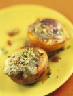 Roast nectarines with pistachios on yellow plate — Stock Photo
