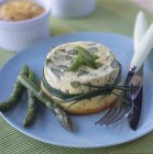 Green asparagus flan on blue plate with fork and knife — Stock Photo