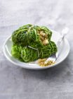 Small cabbages stuffed with tofu and quinoa  on white plate with fork — Stock Photo