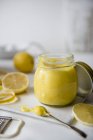 Primo piano vista della cagliata di limone in un barattolo con limoni freschi — Foto stock