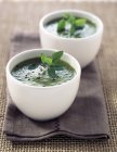 Pea and mint soup in white bowls — Stock Photo