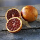 Целые и наполовину кровавые апельсины — стоковое фото